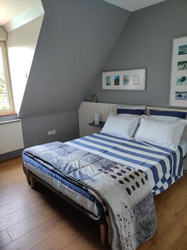a bedroom with a bed with a blue and white blanket at La Hautée des Francs in Veigné