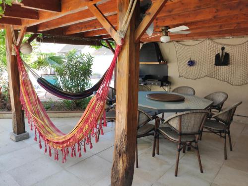 a hammock in a room with a table and chairs at La Hautée des Francs in Veigné