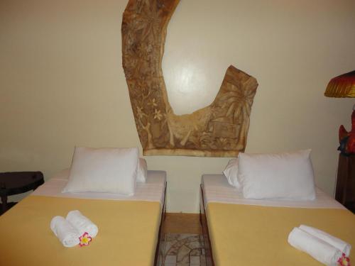 two beds sitting next to each other in a room at Deep Forest Garden Hotel in Puerto Princesa City