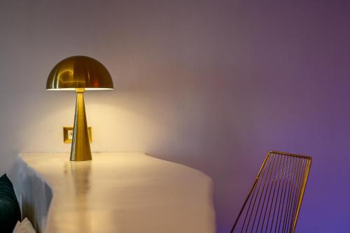 a lamp sitting on a table next to a chair at Canyon Santorini in Fira