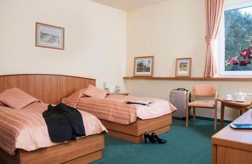 a bedroom with two beds and a desk and a chair at Bobrowy Resort in Zabłudów