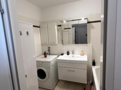 une petite salle de bains avec un lave-linge et un lavabo dans l'établissement Apartment Elena inklusive Garagenplatz, à Vienne