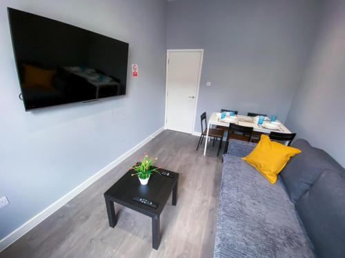 a living room with a couch and a table and a tv at Stylish 1 Bedroom Flat in wood Green in London