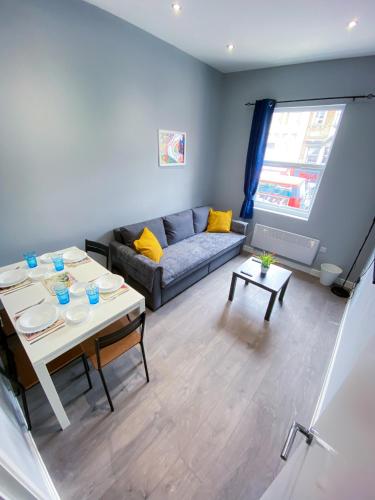 a living room with a couch and a table at Stylish 1 Bedroom Flat in wood Green in London