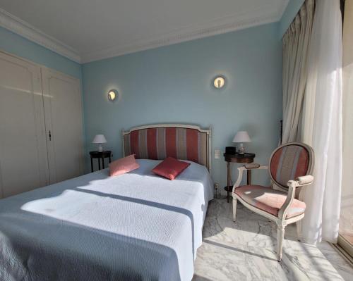 une chambre avec un grand lit et une chaise dans l'établissement LA PRESQU'ILE T2 PALM BEACH MOURE ROUGE, à Cannes