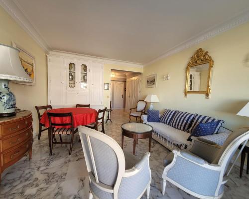 un salon avec un canapé, une table et des chaises dans l'établissement LA PRESQU'ILE T2 PALM BEACH MOURE ROUGE, à Cannes