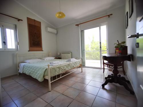 a bedroom with a bed and a table and window at Villa Irene in Kos