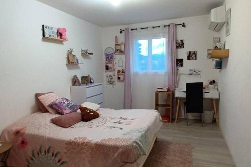 Schlafzimmer mit einem Bett, einem Schreibtisch und einem Fenster in der Unterkunft Appartement agréable pour 6 in Biguglia