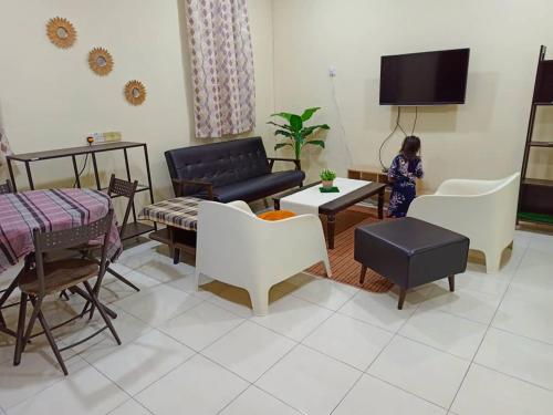 a living room with a couch and a table and chairs at SFY HOMESTAY in Changlun