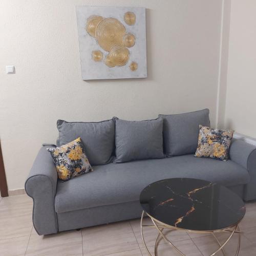 a living room with a blue couch and a table at Hotel Florentina in Constanţa