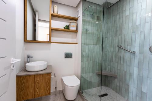a bathroom with a toilet and a glass shower at 25 Chaka's Cove in Ballito