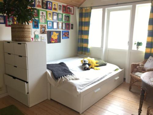 Dormitorio infantil con cama y ventana en Bo nära strand och city., en Västra Frölunda