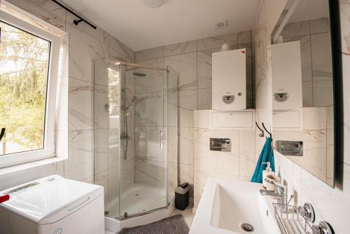 a bathroom with a shower and a sink at Urocza Przystan in Kiemiany