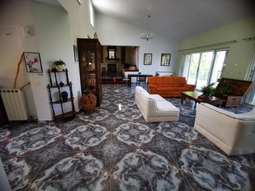 a living room with a large tile floor with couches at Villa Irene in Kos