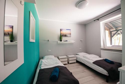 2 łóżka w małym pokoju z oknem w obiekcie Urocza Przystan w mieście Kiemiany