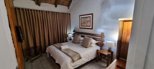 En eller flere senge i et værelse på Bains Lodge