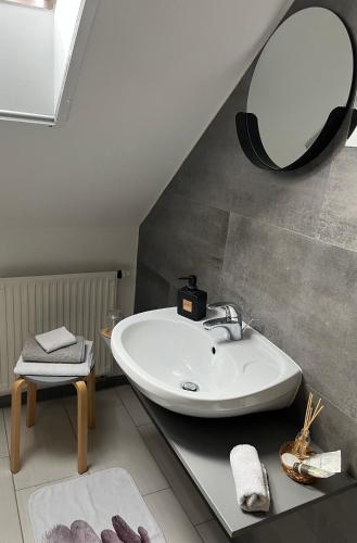 a bathroom with a sink and a mirror on the wall at Jázmin apartmanok in Pogány