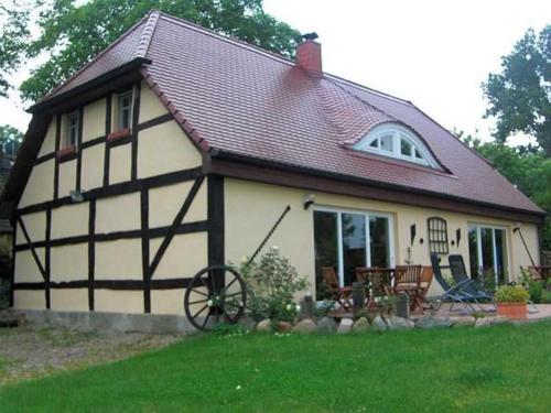 een klein wit en zwart huis met een tuin bij Ruegen Fewo 119 in Groß Schoritz