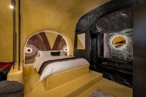 a bedroom with a large bed in a room with a tunnel at Canyon Santorini in Fira