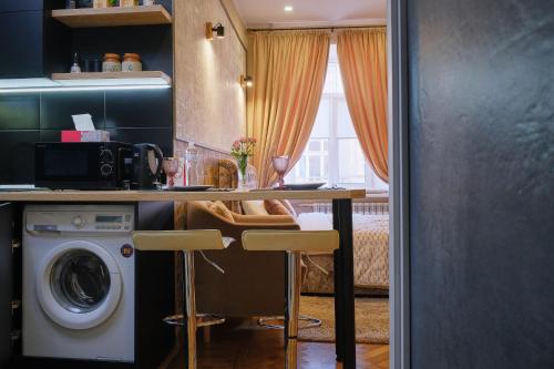 a kitchen with a table and a washing machine at Central Apartments in Odesa