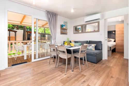 a dining room and living room with a table and chairs at Glamping and Mobile Homes Lavanda - Holiday Centre Bi VIllage in Fažana