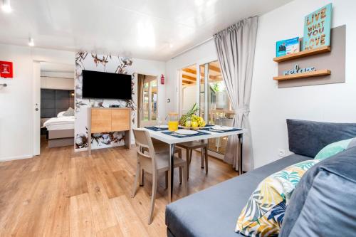 a living room with a table and a bedroom at Glamping and Mobile Homes Lavanda - Holiday Centre Bi VIllage in Fažana