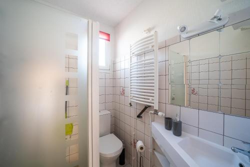 ein weißes Badezimmer mit Toilette und Waschbecken in der Unterkunft Une Maison à la Mer - Proche de la marina in Saint-Cyprien