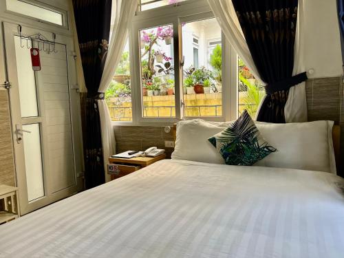 Villa - Hotel Nam Khang 2 Dalat في دالات: غرفة نوم بسرير كبير ونافذة