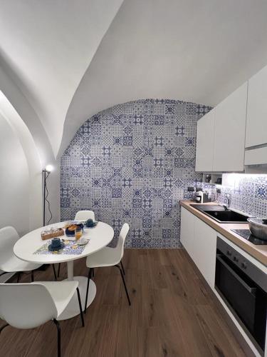 a kitchen with a white table and white chairs at Vico37 Apartment in Acireale