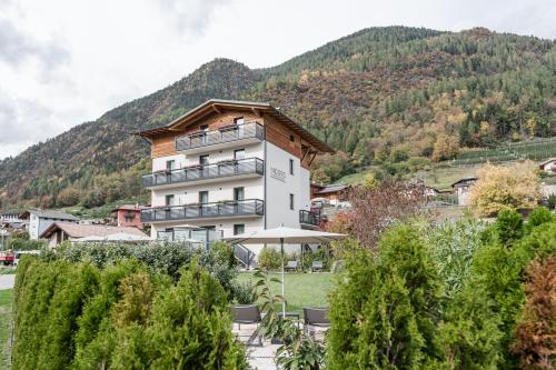 a large white building with a mountain in the background at Nidaris - Luxury Private Spa Suites in Malè