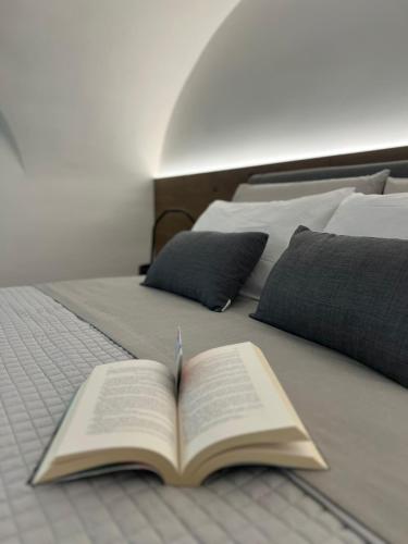 an open book laying on top of a bed at Vico37 Apartment in Acireale