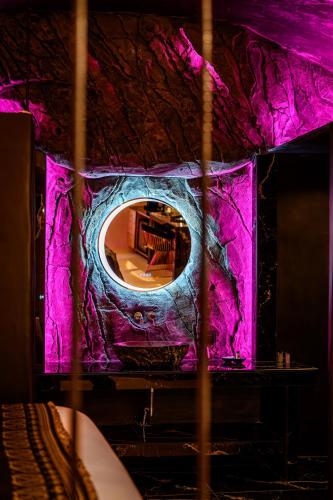 a room with a purple wall with a mirror at Canyon Santorini in Fira