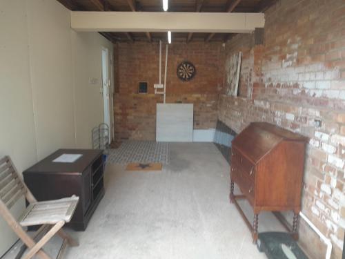 a room with a desk and a chair and a brick wall at Modern Retreat Near Town & Nature with Stunning Views Entertainment and Parking in Burton upon Trent