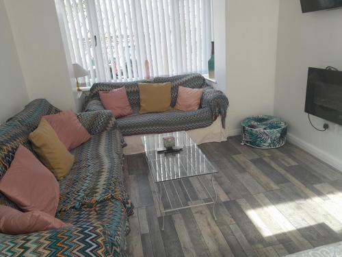 a living room with a couch and a table at Modern Retreat Near Town & Nature with Stunning Views Entertainment and Parking in Burton upon Trent