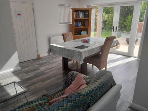 a living room with a table and a couch at Modern Retreat Near Town & Nature with Stunning Views Entertainment and Parking in Burton upon Trent