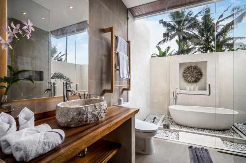 a bathroom with a sink and a tub and a toilet at Villa Sunrise by BaliSuperHost in Ubud