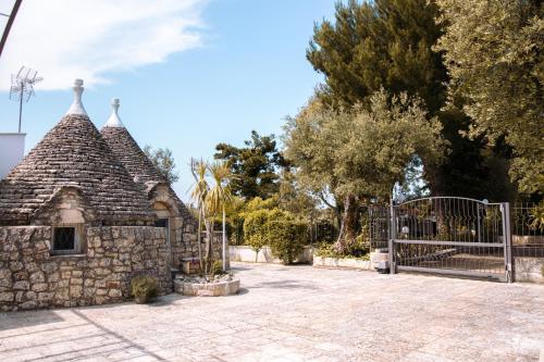 a stone building with a gate and a fence at Il TrullOzio in Castellana Grotte