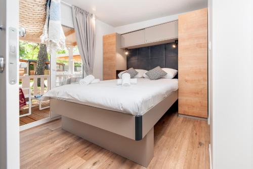 a bedroom with a bed and a balcony at Glamping and Mobile Homes Lavanda - Holiday Centre Bi VIllage in Fažana