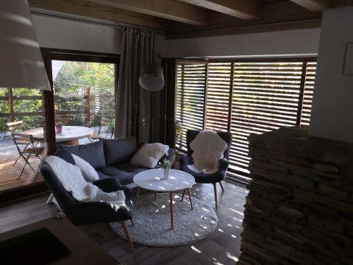 a living room with a couch and chairs and a table at Chalúpka Jánošikove diery in Terchová