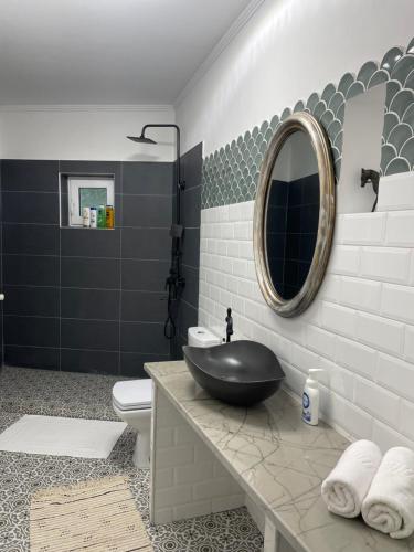 baño con lavabo negro y espejo en Casa Din Targ en Horezu