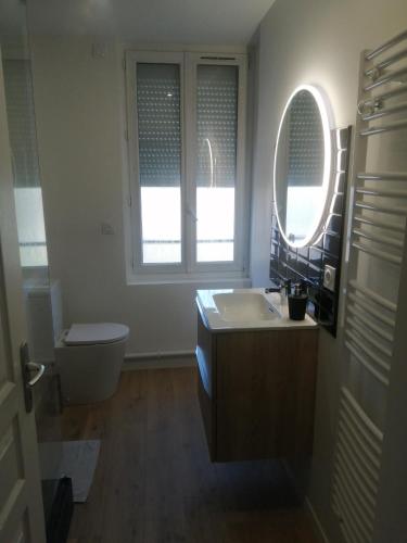 une salle de bain avec un lavabo et des toilettes et une fenêtre dans l'établissement Havre de paix à 5 min de la plage, au Havre