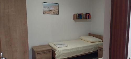 a small bedroom with a bed and a picture on the wall at Apartment Tušek in Jadranovo