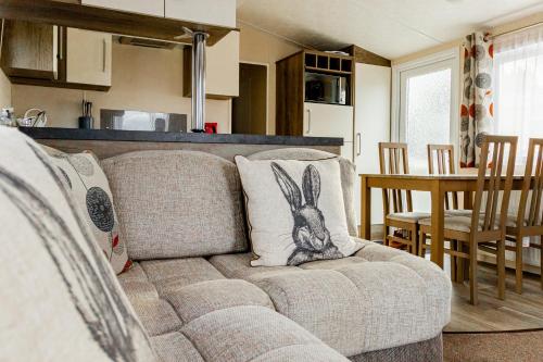 a living room with a couch with a rabbit pillow on it at Wayfarers Inn in Penzance