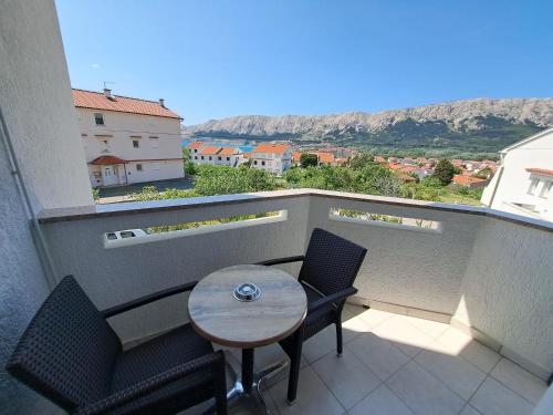a small table and chairs on a balcony with a view at Apartments Leticia in Baška