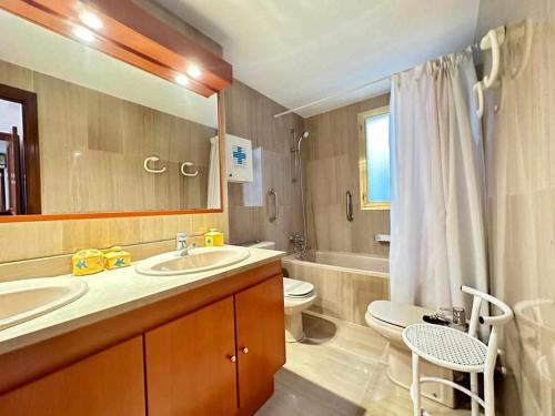 une salle de bain avec deux lavabos et un WC et un miroir dans l'établissement Tossa de Mar Veran, parking Wifi, 100m de la playa, à Tossa de Mar