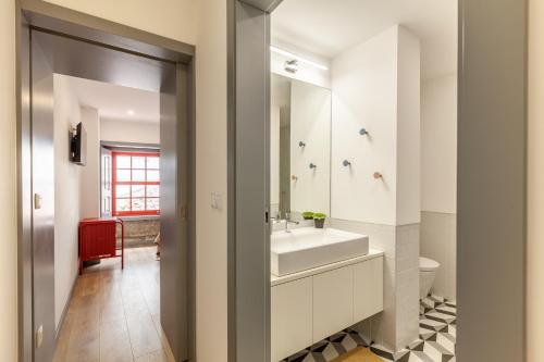 ein Badezimmer mit einem weißen Waschbecken und einem Spiegel in der Unterkunft São Bento Apartment - Minho's Guest in Braga
