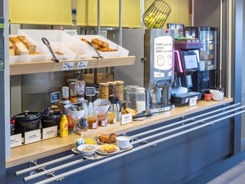 a bakery counter with pastries and other food items at B&B HOTEL Rennes Est Cesson Sévigné in Cesson-Sévigné