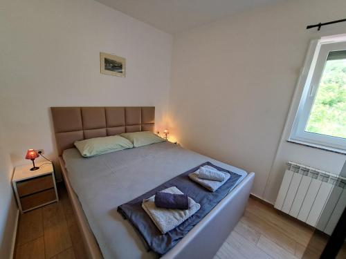 een slaapkamer met een bed met 2 kussens erop bij Apartments Leticia in Baška
