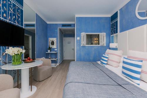 a blue and white bedroom with a bed and a table at Bela Vista Hotel & Spa - Relais & Chateaux in Portimão