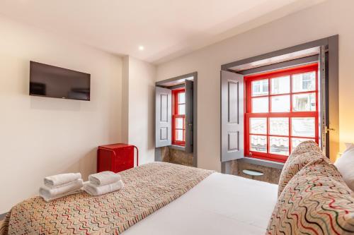 ein Schlafzimmer mit einem Bett und einem TV an der Wand in der Unterkunft São Bento Apartment - Minho's Guest in Braga